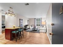 Bright living room with bar seating, wood floors, stylish rug, and ample natural light at 1421 Peachtree Ne St # 211, Atlanta, GA 30309