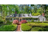 Charming home with a brick walkway, manicured landscaping, and a lush green lawn at 2890 Howell Mill Rd, Atlanta, GA 30327