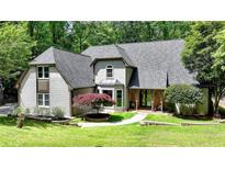 Charming two-story home with landscaped yard and brick accents near lush greenery and mature trees at 1595 Northcliff Trce, Roswell, GA 30076