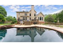 Backyard features a lovely pool with a brick trimmed deck and a cozy porch in a private backyard at 1721 Mulberry Lake Dr, Dacula, GA 30019