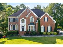Charming two-story brick home featuring a beautifully landscaped front yard and classic architectural details at 3705 Rolling Creek Dr, Buford, GA 30519