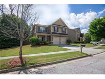 Charming two-story home featuring a well-manicured lawn and a two-car garage, creating an inviting curb appeal at 4271 Haywater Cv, Buford, GA 30519