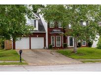 Charming two-story brick home with a well-manicured lawn and a two-car garage at 1185 Charter Club Dr, Lawrenceville, GA 30043