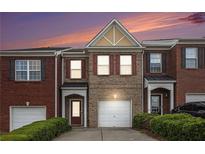 Charming brick townhome with a one-car garage and a well-manicured front yard at 2279 Hawks Bluff Trl, Lawrenceville, GA 30044