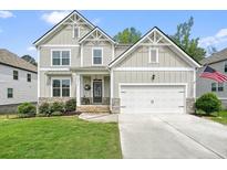 Charming two-story home with a two-car garage, manicured lawn, and stone accents at 6915 Rambling Vale, Cumming, GA 30028