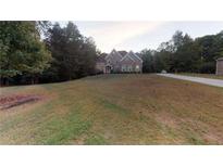 Charming brick home with a well-maintained lawn and mature trees providing shade and privacy at 4255 Ben Hill Rd, Atlanta, GA 30349
