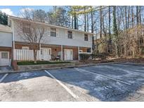 Inviting two-story townhouse with neutral siding, brick accents, and a convenient parking area for residents and visitors at 6027 Wintergreen Rd, Norcross, GA 30093