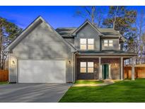 Charming two-story home featuring gray siding, a brick-accented porch, and a two-car garage at 4806 Forest Trl, Douglasville, GA 30135
