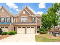 Charming brick townhome with a two-car garage, manicured lawn, and inviting curb appeal at 1957 Brightleaf Way # 59, Marietta, GA 30060