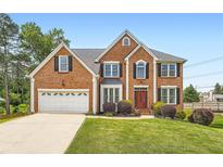 Charming two-story brick home featuring an attached garage, landscaped front yard, and a welcoming red front door at 3363 Linton Ln, Marietta, GA 30066