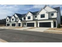 Modern townhome exteriors featuring white siding, black trim, and individual garages at 200 Starr Cir, Stockbridge, GA 30281