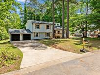 Charming home with a two-car garage, long driveway, and beautiful yard surrounded by mature trees at 4058 Daron Ct, Ellenwood, GA 30294