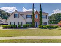 Charming two-story home with well-manicured lawn and mature landscaping at 1043 Lexus Dr, Lawrenceville, GA 30045