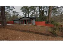 Charming single-story home with gray siding, an orange fence, and a well-maintained lawn at 3479 Thompson Nw Dr, Atlanta, GA 30331