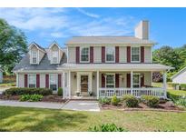 Charming two-story home featuring a welcoming front porch and manicured landscaping in a suburban neighborhood at 1625 Summit View Way, Snellville, GA 30078