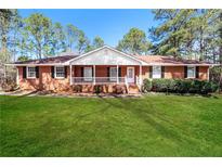 Charming one-story brick home features a well-manicured lawn and a welcoming front porch at 2417 Jade Dr, Lawrenceville, GA 30044