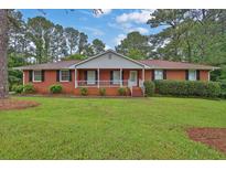 Charming brick home with a well-manicured lawn and a cozy front porch at 2417 Jade Dr, Lawrenceville, GA 30044