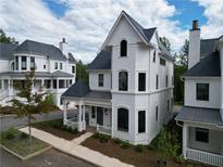 Charming white home with black roof and a covered porch, creating a welcoming curb appeal at 11530 Serenbe Ln, Chattahoochee Hills, GA 30268