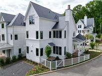 Stunning exterior view of a bright white home with a well-manicured lawn and a charming white picket fence at 11530 Serenbe Ln, Chattahoochee Hills, GA 30268