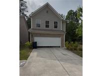 Charming two-story home featuring a brick and siding exterior with an attached two-car garage and a well-maintained driveway at 2285 Crossrail Dr, Atlanta, GA 30349