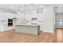 Bright kitchen features white cabinets, stainless appliances, large island, and hardwood floors at 2556 Silver Star Ne Dr, Marietta, GA 30066