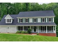 Charming two-story home featuring a welcoming front porch, well-manicured lawn, and attached two-car garage at 2976 Matthew Ln, Lawrenceville, GA 30044