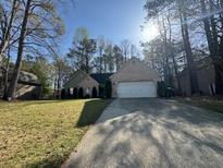 Traditional home featuring brick and siding exterior, well-maintained lawn, and a spacious driveway at 1642 Ashmar Sw Ln, Marietta, GA 30064
