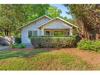 Charming craftsman home with stone facade, covered porch, mature landscaping, and a well-manicured lawn at 1761 Flat Shoals Se Rd, Atlanta, GA 30316