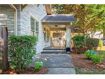 Charming front porch with stone accents and a cozy seating area, surrounded by lush greenery at 1761 Flat Shoals Se Rd, Atlanta, GA 30316