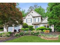 Charming two-story home featuring manicured landscaping, flowering shrubs, and a well-maintained lawn at 2437 Camden Lake Nw Vw, Acworth, GA 30101