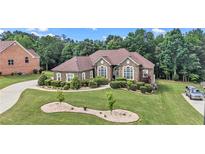Charming single-story home featuring a well-manicured lawn and lush landscaping at 2628 Hollow Pne, Conyers, GA 30094