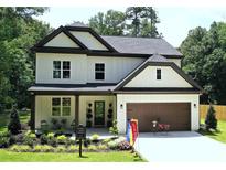 Charming two-story home features a manicured front yard, covered porch, and a two-car garage at 2610 Lisa Sw Dr, Atlanta, GA 30311