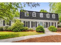 Charming white brick home with black shutters and landscaped front yard, featuring a classic, inviting aesthetic at 4774 Olde Village Ln, Atlanta, GA 30338