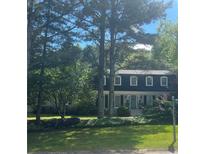 Charming two-story home with a landscaped lawn, blue door and mature trees providing ample shade at 4774 Olde Village Ln, Atlanta, GA 30338