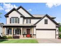 Charming two-story home featuring a welcoming front porch and a well-maintained lawn at 6235 Crescent Landing Dr, Cumming, GA 30028