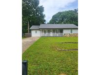 Charming one-story home featuring a white porch, stone accents, and a lush green lawn at 324 Cynthia Ct, Jonesboro, GA 30238