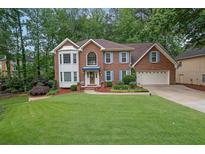 Charming two-story brick home with a well-manicured lawn and attached two-car garage at 4373 Mikandy Nw Dr, Kennesaw, GA 30144