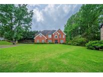 Spacious brick home featuring a well-maintained lawn and mature trees at 5610 Mountain Meadow Ct, Stone Mountain, GA 30087