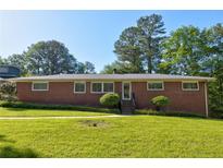 Charming brick home featuring a well-manicured lawn and mature trees at , Mableton, GA 30126