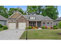 Charming single-Gathering home with stone accents, a two-car garage, and a beautifully landscaped front yard at 6805 Bransford Dr, Cumming, GA 30040