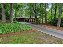 Charming home nestled in a wooded lot featuring a long driveway and brick facade at 2700 Regency E Dr, Tucker, GA 30084