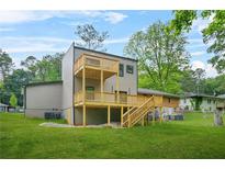 Modern home featuring an expansive multi-level wooden deck, perfect for outdoor entertaining, surrounded by lush greenery at 2318 Polar Rock Terrace, Atlanta, GA 30315
