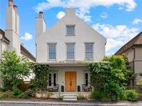 Charming three-story home with a symmetrical facade, covered porch with lush greenery, and striking architectural details at 110 3Rd St, Fayetteville, GA 30214