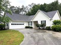 Charming single-story home with white siding, black shutters, and a two-car garage at 1255 Summit Point Ln, Snellville, GA 30078