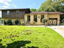 Charming two-story home featuring a well-manicured front yard and unique architectural details at 1244 Hickory Wood Ne Dr, Woodstock, GA 30188