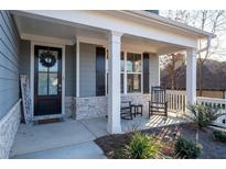 Charming front porch featuring rocking chairs and a welcoming entrance with a wreath on the door at 15 Parkside Vw, Cartersville, GA 30121
