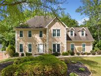 Charming two-story home featuring a well-manicured lawn, complemented by lush, mature trees providing ample shade at 1770 Laurel Creek Dr, Lawrenceville, GA 30043