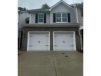Two car garage of a two-story home with grey siding and black shutters at 1155 Park Center Cir, Austell, GA 30168