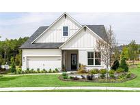 Charming two-story home features a well-manicured lawn, crisp white siding, and an attached two-car garage at 210 Mooney Rd, Woodstock, GA 30188