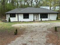 Charming home featuring black trim, white siding, and a large gravel driveway at 12778 Cumming Hwy, Canton, GA 30115